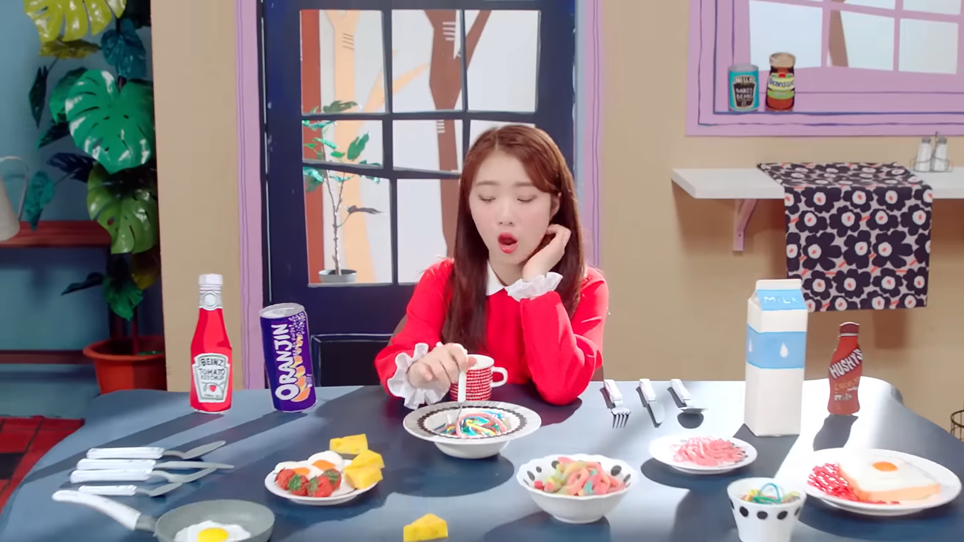 Yeojin sitting at the table picking at a bowl of candy.